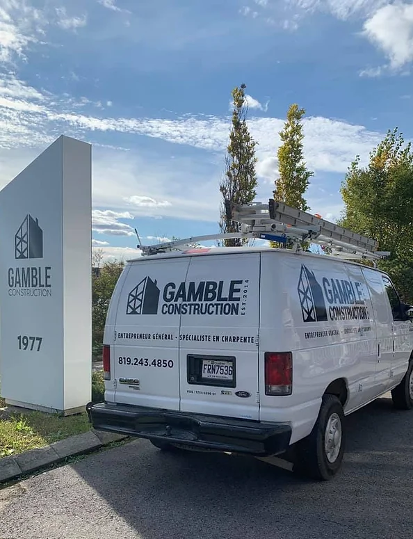 Photo d'un camion de Gamble Construction devant leur enseigne